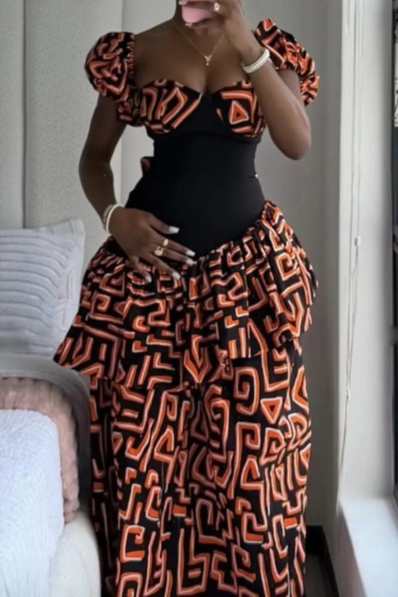 A person wearing a black and orange patterned dress with dramatic large puff sleeves.