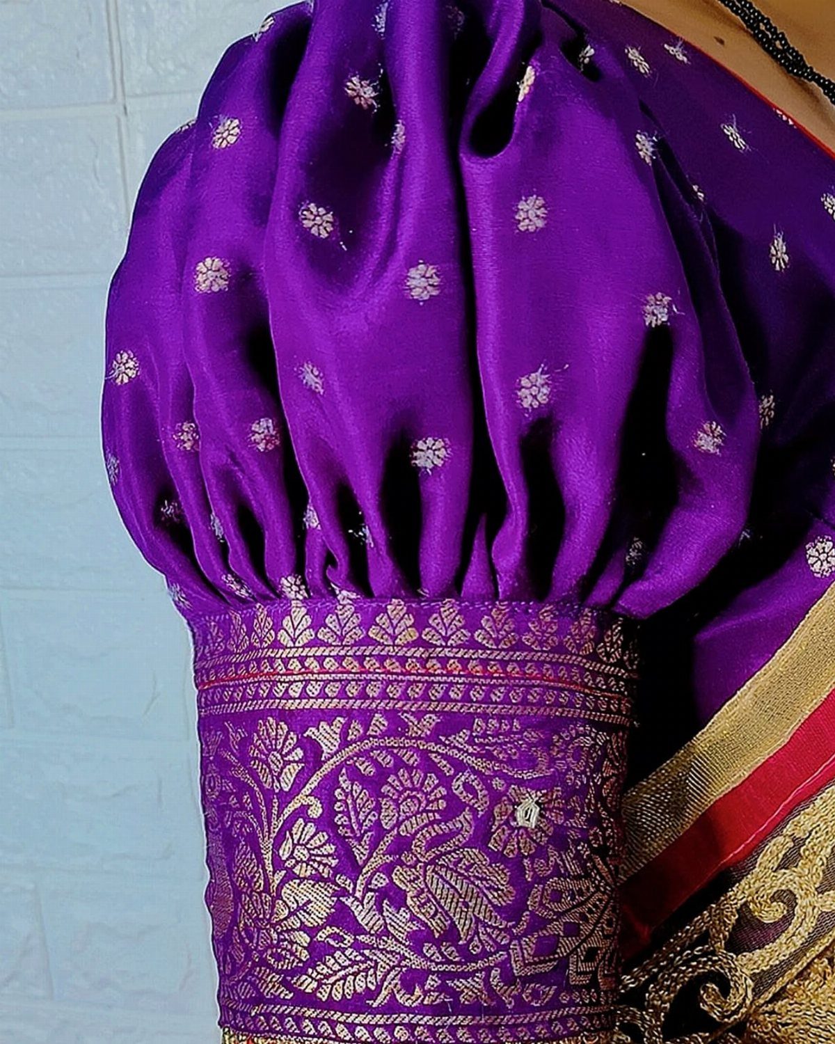 Purple silk blouse with voluminous puff sleeves and intricate gold zari embroidery on the cuffs.