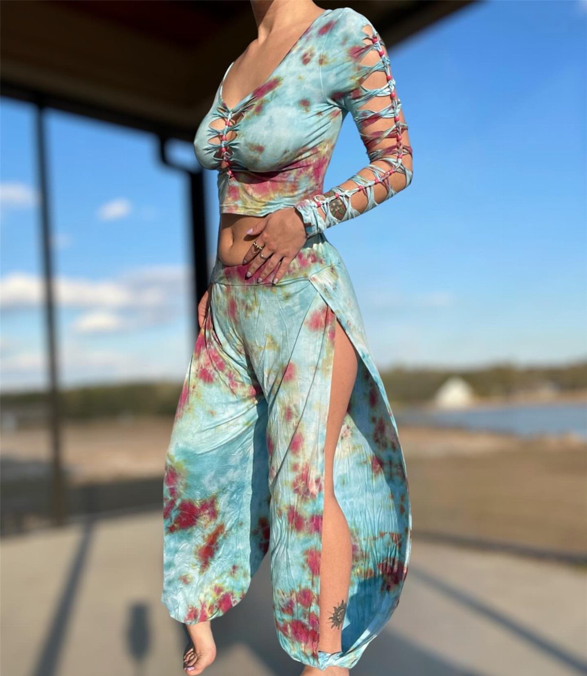 A person wearing a blue and red tie-dye matching two-piece crop top and skirt set.