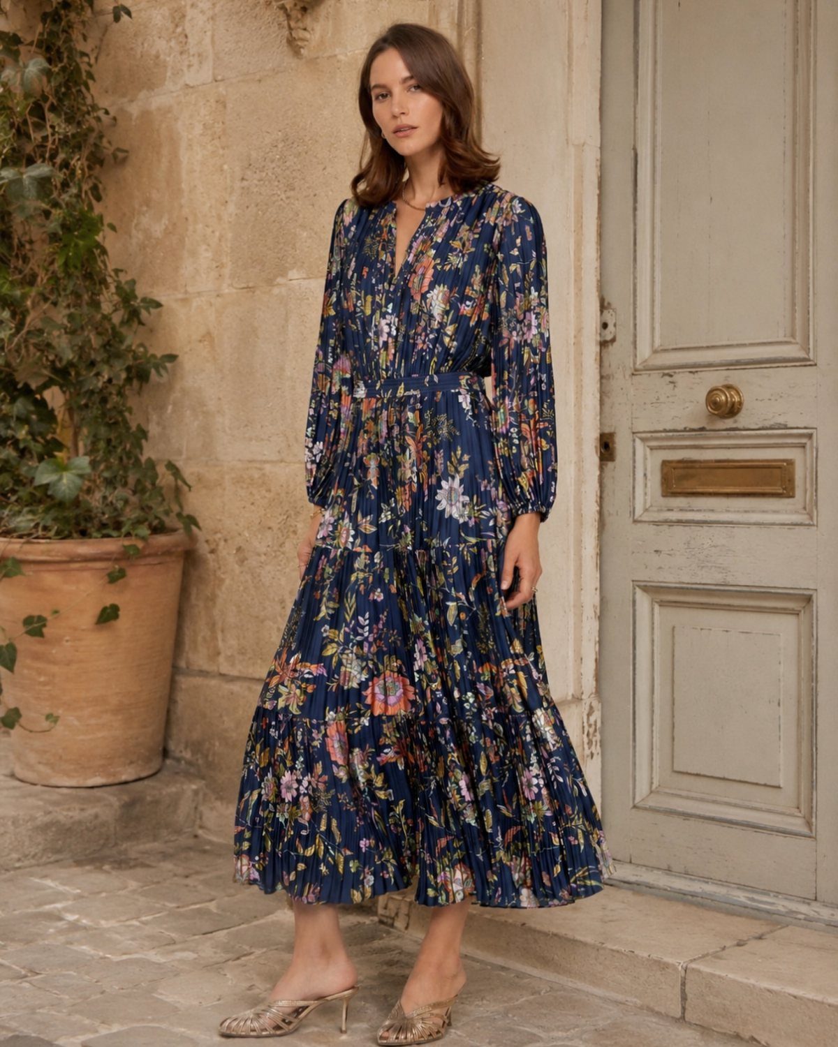 A woman wearing a navy blue floral print long sleeve midi dress standing outdoors.