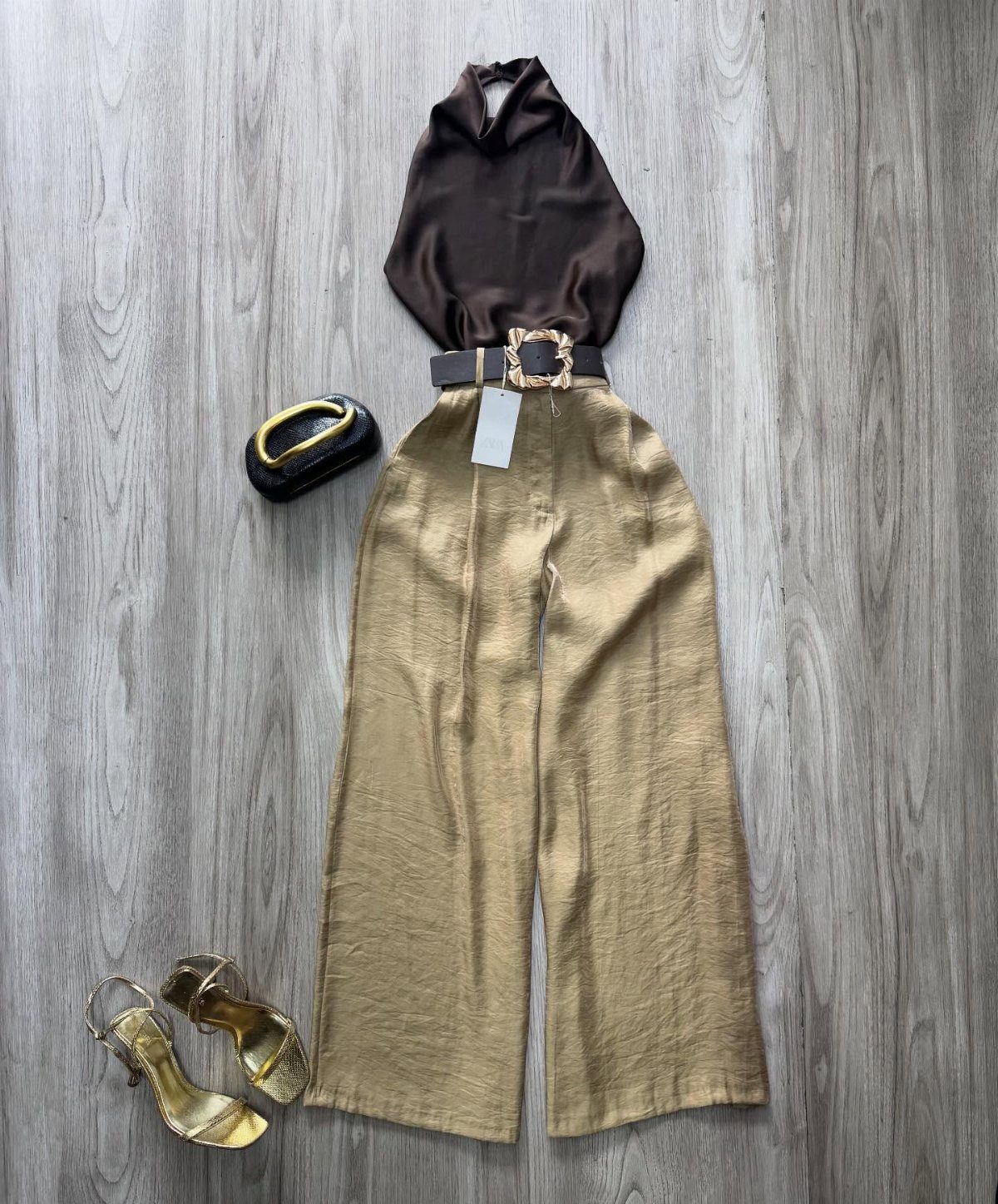 Gold metallic wide-leg pants paired with a brown blouse, black belt, and gold sandals.
