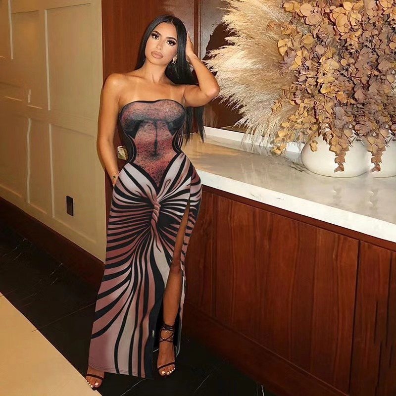 Woman wearing a patterned strapless bodycon dress with a high leg slit standing indoors.