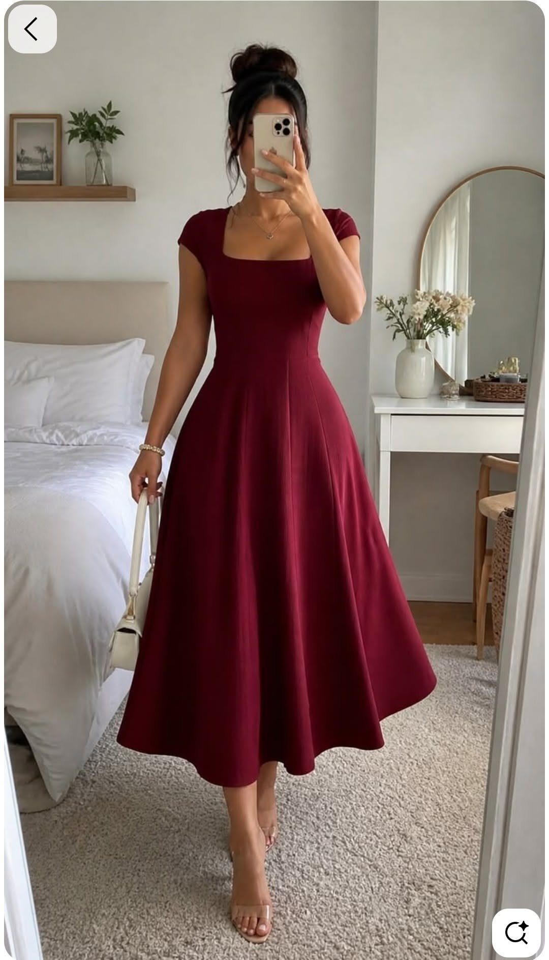 Woman in a maroon fit-and-flare midi dress posing for a mirror selfie in a bedroom.