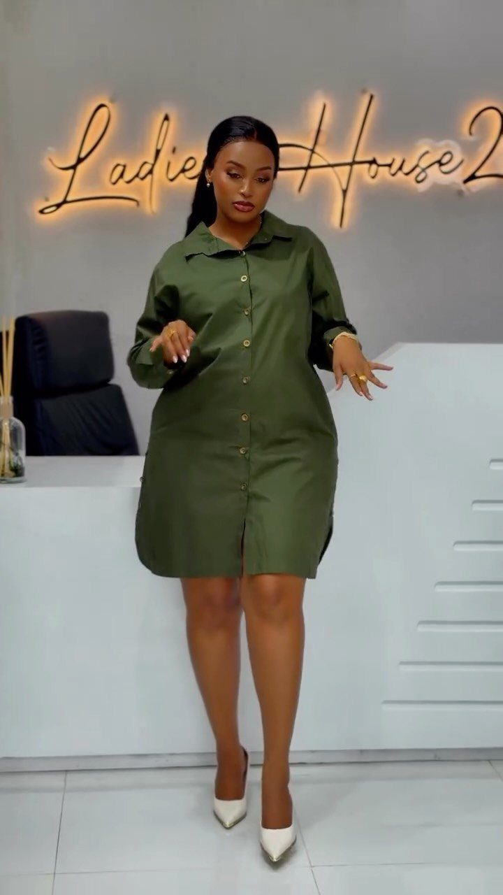 Woman posing in an olive green shirt dress and white high heels.