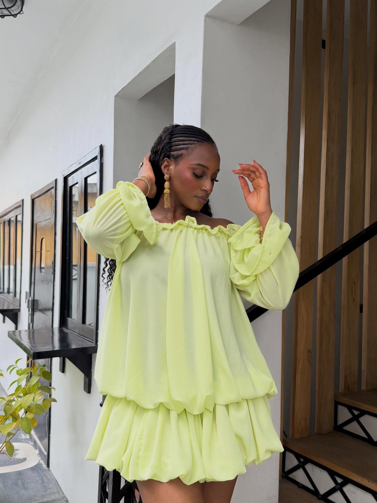Woman posing in a lime green off-the-shoulder dress with a voluminous bubble hem.