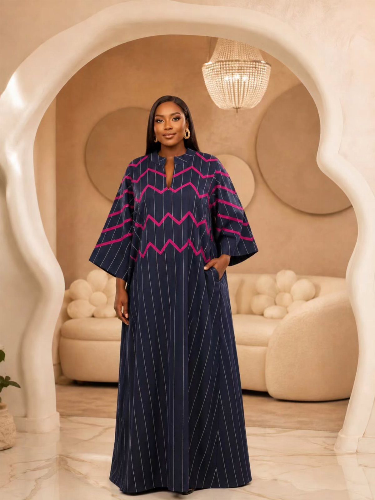 Woman wearing a dark blue maxi dress with pink chevron patterns and white vertical stripes.