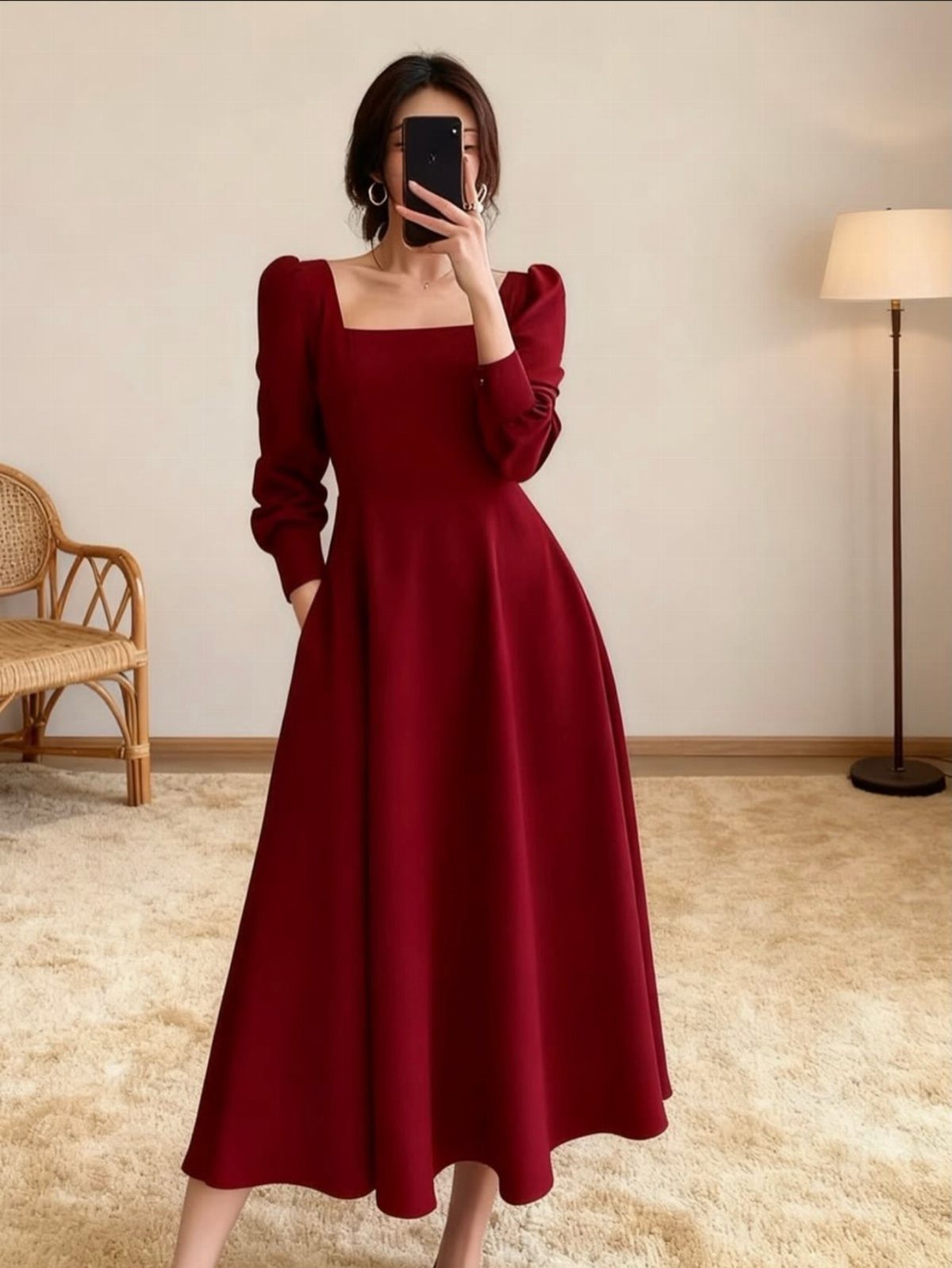 Woman in a long-sleeved red midi dress with a square neckline standing in a room.