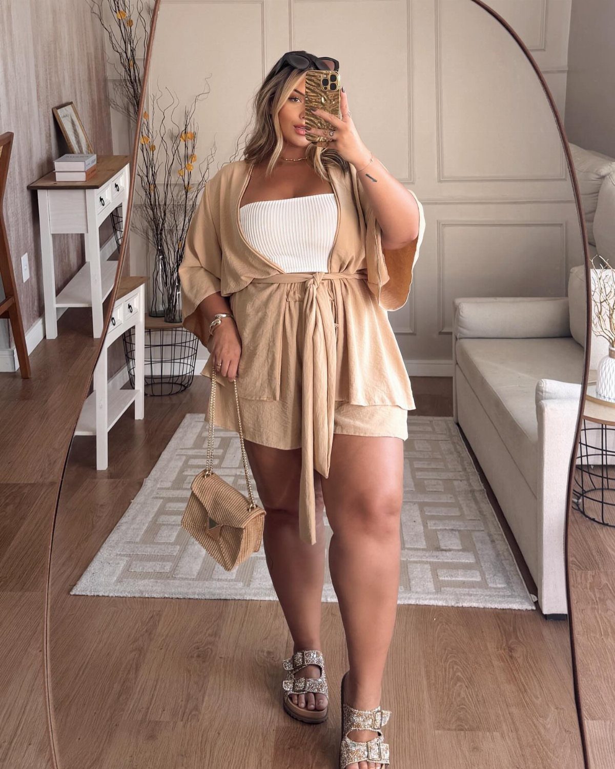 A woman posing in a tan wrap-style cover-up set and embellished sandals.