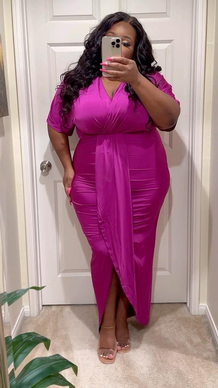 Woman in a magenta wrap midi dress and clear heels posing for a mirror selfie.