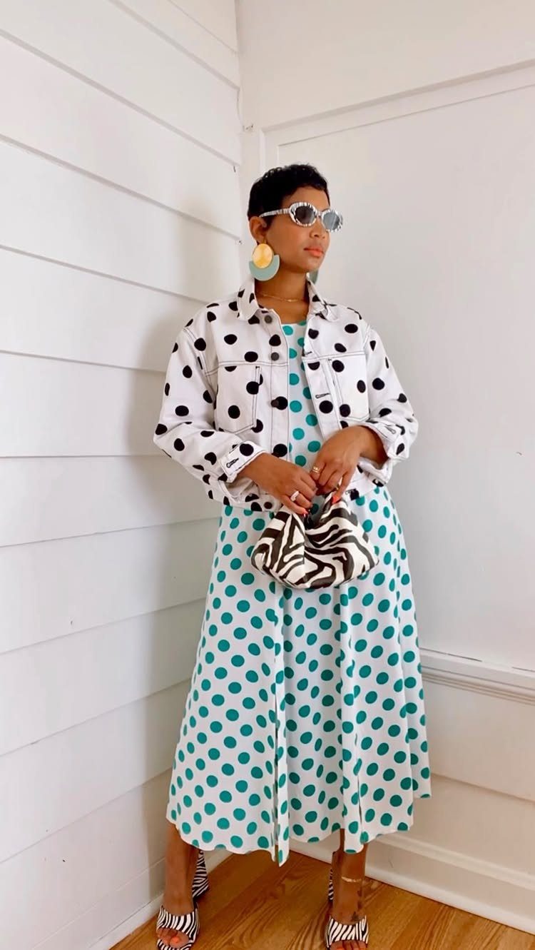 Person wearing a polka dot denim jacket over a teal polka dot midi dress with zebra print accessories.