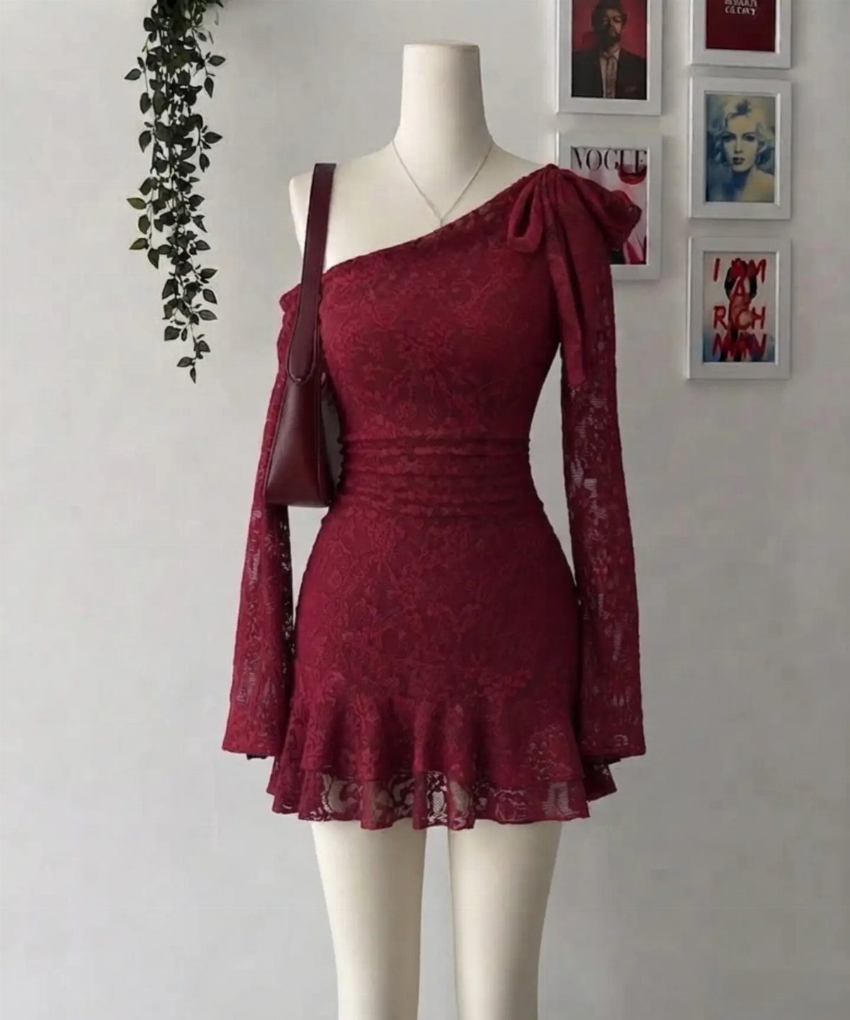 A cherry red lace bodycon mini dress displayed on a white mannequin against a wall.