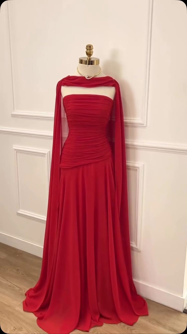 A red chiffon strapless gown with a ruched bodice displayed on a white mannequin.