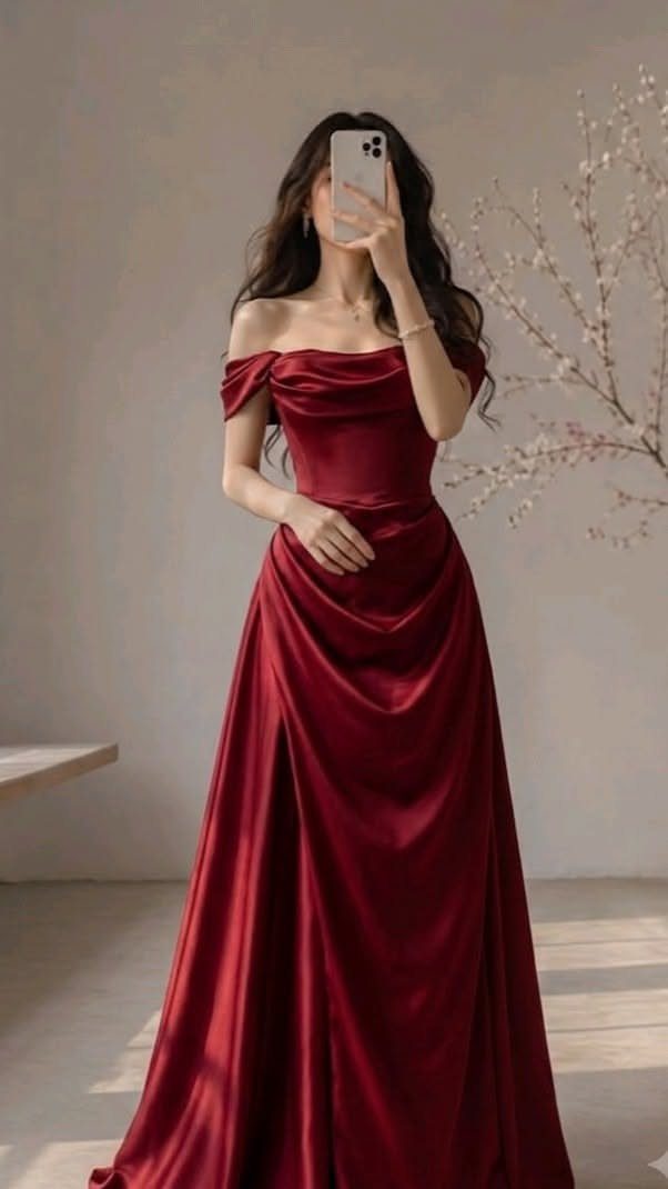 Woman posing in a long, off-the-shoulder red satin A-line evening gown.