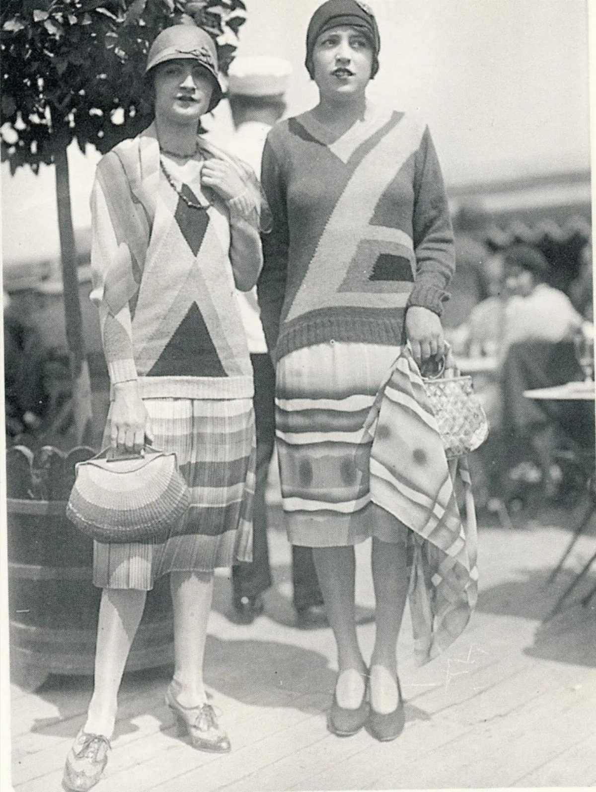Two women wearing 1920s fashion with bold geometric patterns on their clothing.