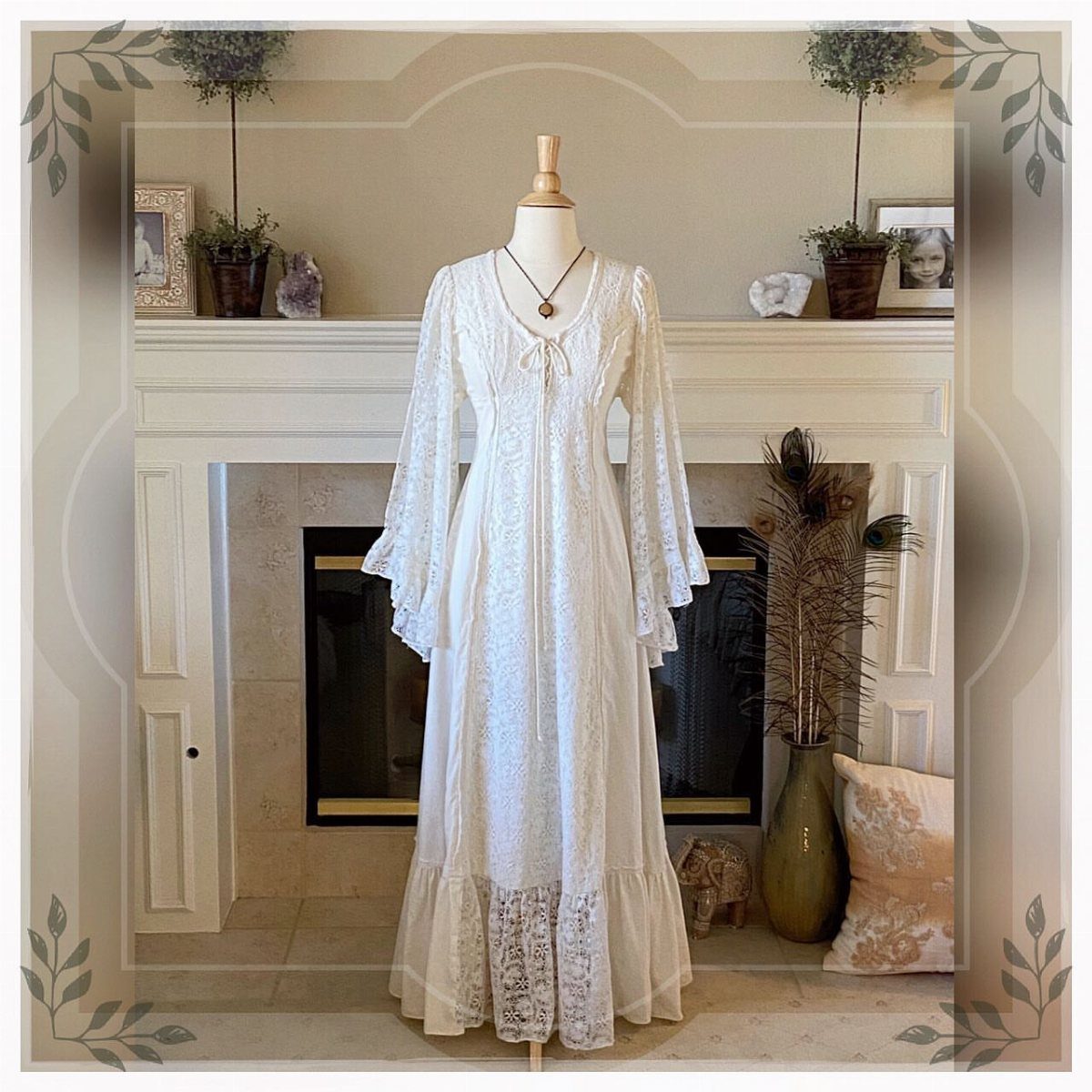 White lace maxi dress with long flowing angel sleeves displayed on a mannequin.