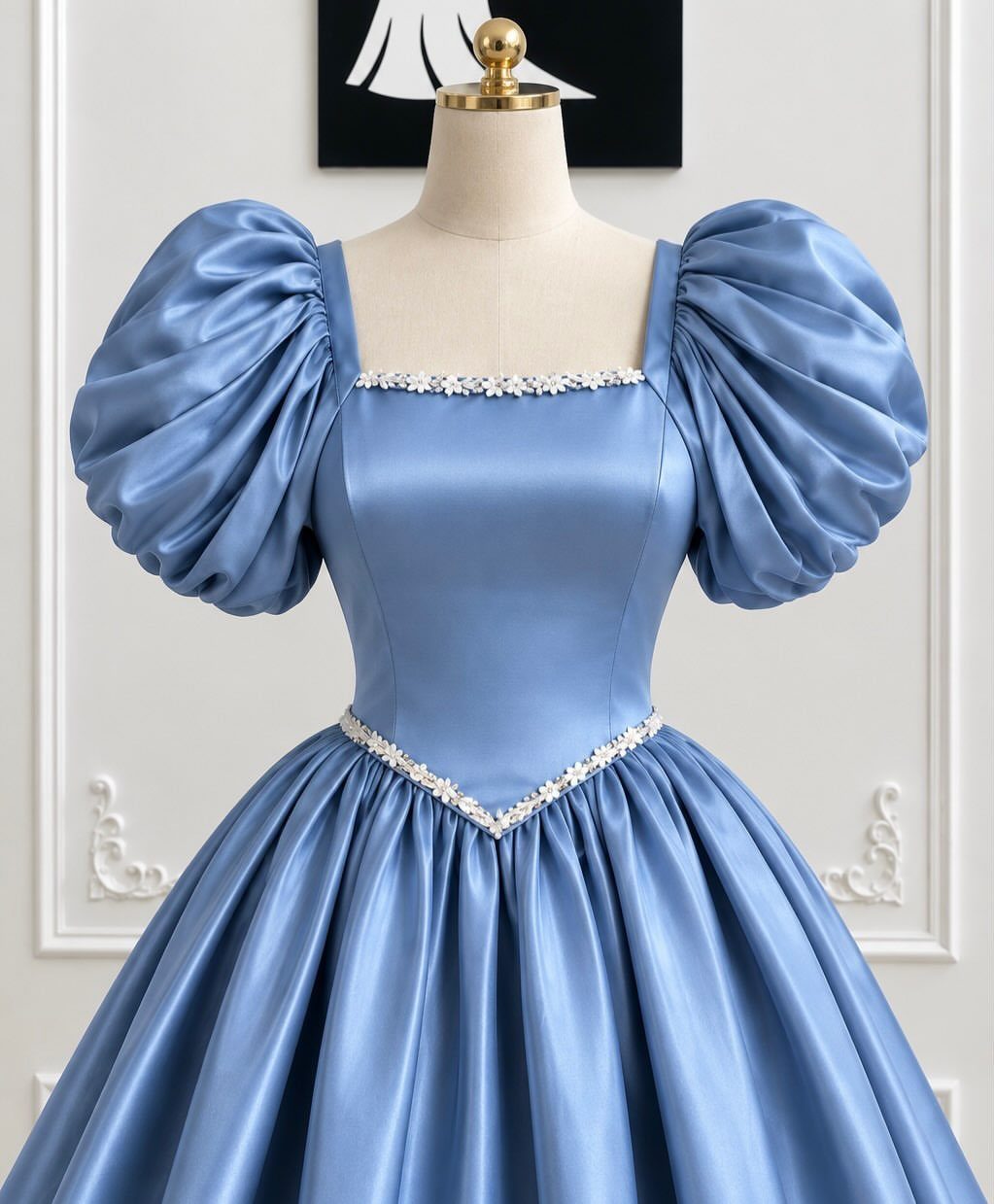A light blue satin dress with a square neckline and puffed sleeves on a mannequin.
