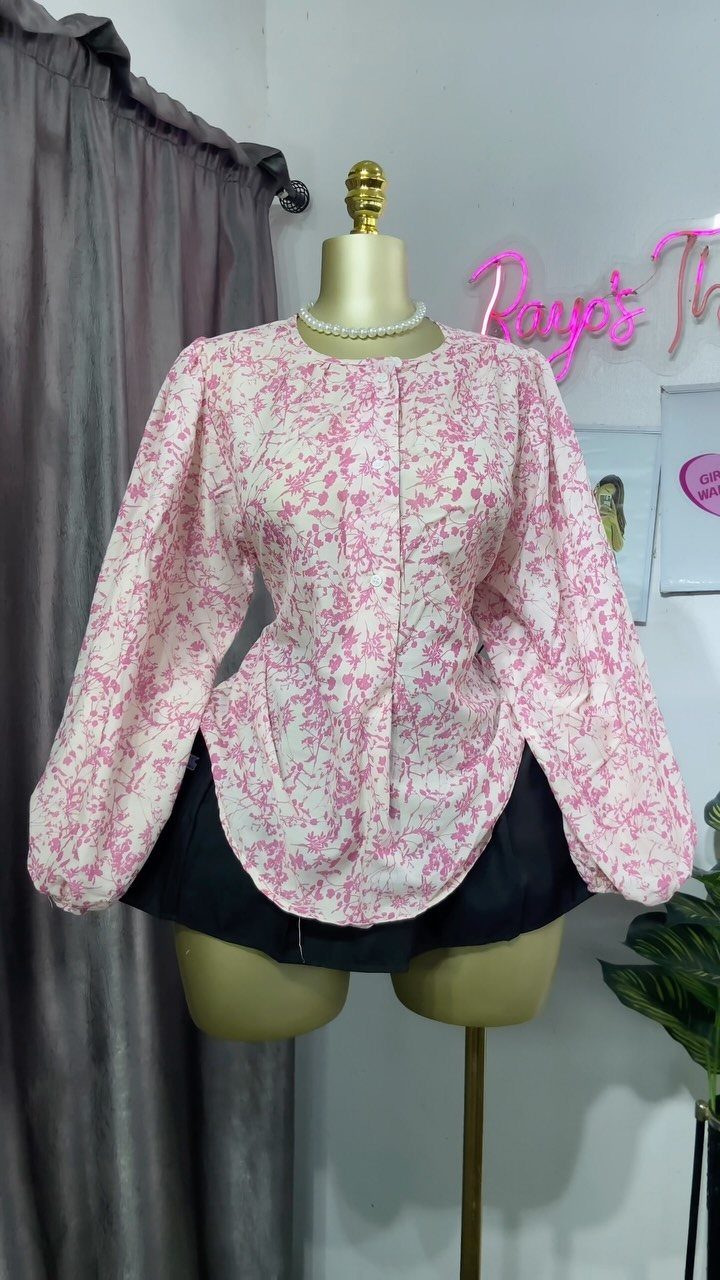 A pink and white floral puff sleeve blouse displayed on a mannequin torso.