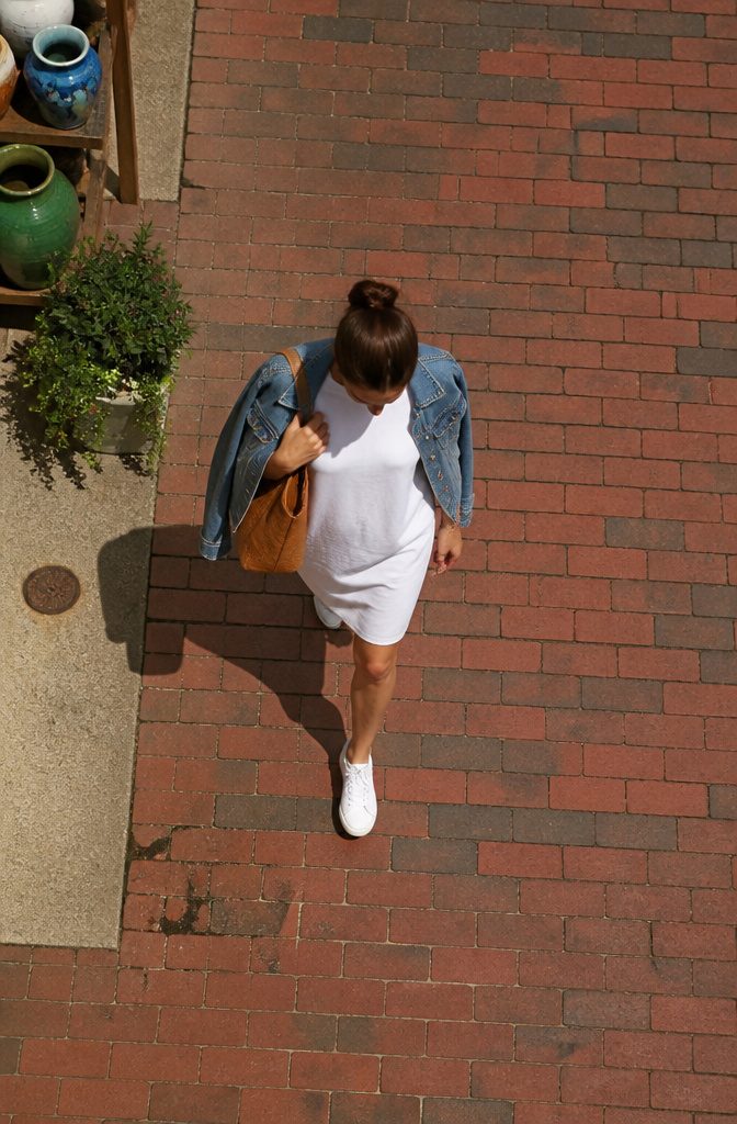 A model wearing a white t-shirt dress.