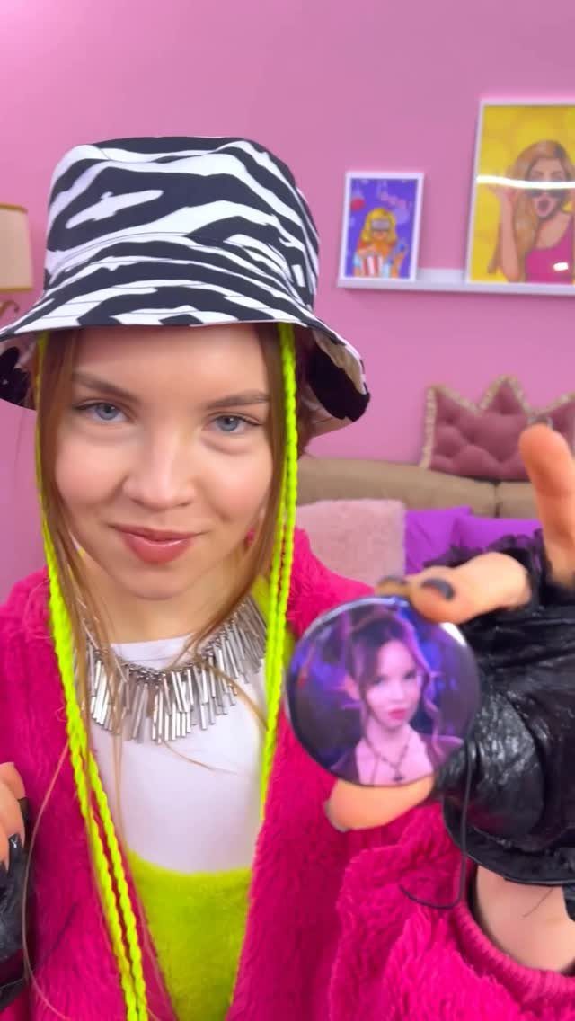 A young woman wearing a zebra print bucket hat and bright pink fuzzy jacket.